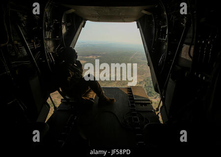 DARWIN, Australien-US Marine Sgt. Phil Berry, Waffen und Taktiken Lehrer, Marine Medium Tiltrotor Squadron 268, Marine Rotations Kraft Darwin, blickt der Rückseite ein MV-22 Osprey, wie sie ihren Weg zu holen, ein Hubschrauber-Support-Team für ein Aussenlift, 26. Mai 2017. Dies ist der Fischadler ersten Einsatz nach Australien und die Interoperabilität Ausbildungskapazitäten für die Australian Defence Force und der US-Marines hinzugefügt hat. Berry, 28 Jahre alt, ist von Annapolis, Maryland (U.S. Marine Corps Foto von Sgt. Emmanuel Ramos) Stockfoto