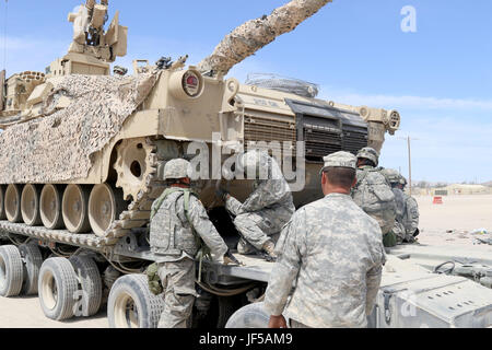 Soldaten der 1175th Transportation Company, Tennessee Army National Guard, sichern einen Abrams-Kampfpanzer auf einem schweren Gerätetransporter während einer 155th Armored Brigade Combat Team Rotation in Fort Irwin, Kalifornien. Stockfoto