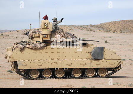 Bradley Fighting Vehicle Kommandant mit dem 155. gepanzerte Brigade Combat Team zeigt die Richtung an in Richtung eines Dorfes für eine kombinierte Waffen-Training im National Training Center in Fort Irwin, Kalifornien am 30. Mai 2017 zu bewegen. (Mississippi National Guard Foto von Sgt. Edward Lee, 102d Public Affairs-Abteilung) Stockfoto