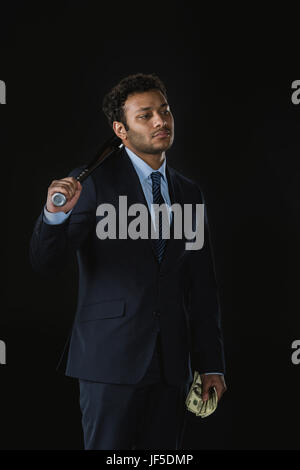 Ernst junger Geschäftsmann mit Baseball Schläger und Dollar-Banknoten wegschauen Stockfoto