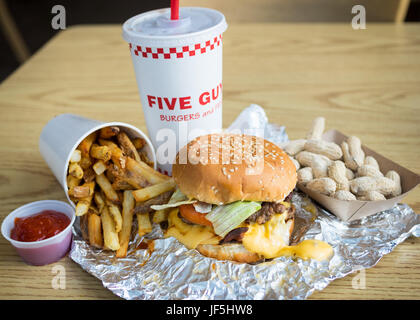 Ein Bacon Cheeseburger, Pommes Frites und Erdnüsse aus fünf Jungs Burger und Pommes, eine amerikanische fast-casual-Restaurant-Kette. Stockfoto