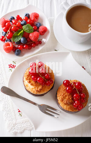 Leckeres Frühstück, Kokos Muffins, Beeren und Kaffee mit Milch Nahaufnahme auf dem Tisch. vertikale Ansicht von oben Stockfoto