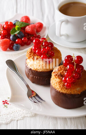 Köstliches Dessert: Kokos-Muffins mit Sommerbeeren und Kaffee-close-up auf dem Tisch. vertikale Stockfoto