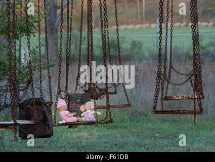 Verlassene Kinder Puppe und Soft Toy auf Swing Stockfoto