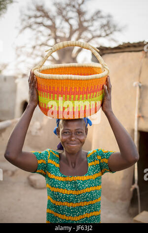 Eine Frau hält einen traditionellen Stroh Korb Upper East Region, Ghana. Stockfoto