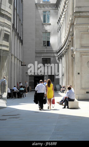 Rückansicht des stilvollen Geschäftsfrau im gelben Sommerkleid, zu Fuß durch Hof in The City of London UK KATHY DEWITT Stockfoto