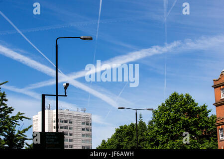 Flugzeug-Kondensstreifen über den Himmel in London.These zeigen die Trails durch Flugzeuge, die in Wolken verwandeln und verschmutzen die Umwelt Links Stockfoto