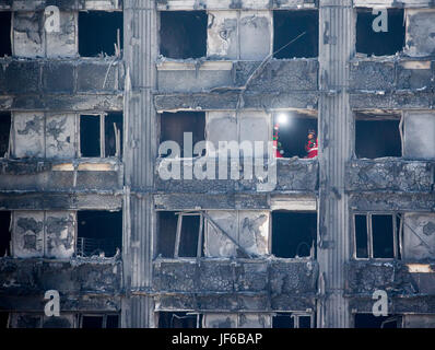 Such- und Rettungsteams durchsuchen die verkohlten Überreste des Turmes Grenfell in Latimer Road Stockfoto