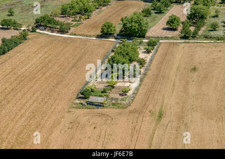 Luftaufnahme des Feldes gepflanzt mit Müsli und einem Obstgarten in der Mitte im Dorf des Frias, Provinz Burgos, Castilla y León, Spanien, Europa. Stockfoto