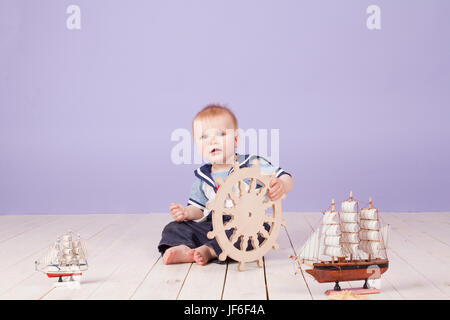 ein kleiner Junge, gekleidet wie ein Matrose Kapitän des Schiffes Stockfoto