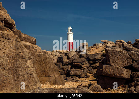 Portland Bill Leuchtturm an einem schönen Sommertag, Darstellung der Steinbrüche Fels und Geröll Bildung im Vordergrund mit einem klaren blauen Himmel. Stockfoto