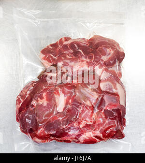 Frisches rohes, rotes Fleisch vakuumiert in Kunststoff verlängern die Haltbarkeit oder Lagerzeit durch die Extrusion der Luft in eine Nahaufnahme der Draufsicht Stockfoto
