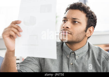Close-up Portrait von konzentrierten Jungunternehmer Papier drinnen halten Stockfoto