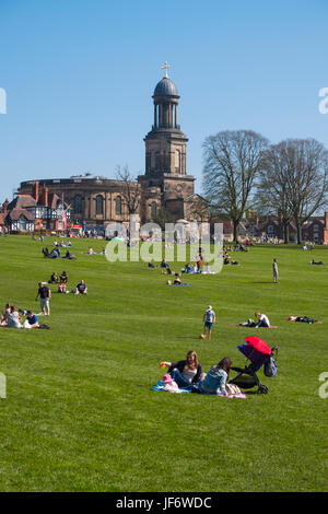 Familien genießen die Sonne in der Steinbruch in Shrewsbury übersehen von St. Chad Kirche, Shropshire, England, UK Stockfoto