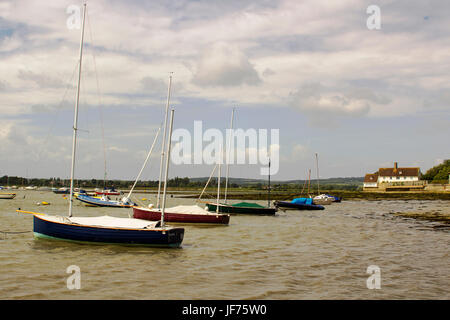 Sportboote auf ihren Liegeplätzen im historischen Hafen Bosham in West Sussex im Süden Englands Stockfoto