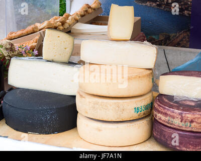 Gruppe von natürlichen Bergkäse hergestellt in traditioneller Weise in den europäischen Alpen in einem Marktstand auf einem Jahrmarkt gestapelt Stockfoto