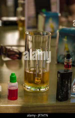 Verdampfer und fast leer Bier mit Flasche und Gabel am Tisch Stockfoto