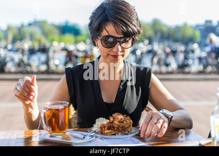 attraktive dunkelhaarige Frau mit Tee und Apfel-Torte im café Stockfoto