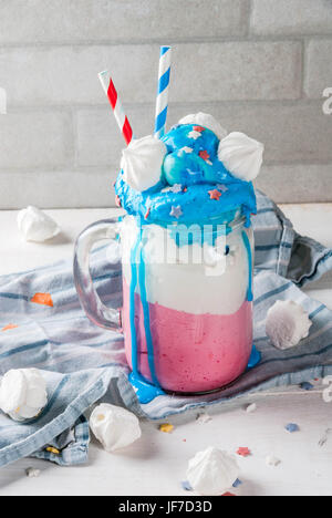 Leckereien für Independence Day Feiertag, Juli 4. Hausgemachter Milchshake, verrückte Shake mit Eis, in den traditionellen Farben - blau, rot, weiß, verziert mit Stockfoto