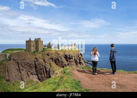 Touristen, die gerne am Dunnottar Castle, zerstörten mittelalterlichen Festung in der Nähe von Stonehaven auf Klippe entlang der Nordsee Küste, Aberdeenshire, Schottland, UK Stockfoto