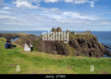 Touristen, die gerne am Dunnottar Castle, zerstörten mittelalterlichen Festung in der Nähe von Stonehaven auf Klippe entlang der Nordsee Küste, Aberdeenshire, Schottland, UK Stockfoto