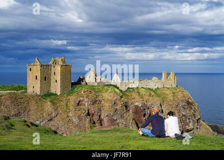 Touristen, die gerne am Dunnottar Castle, zerstörten mittelalterlichen Festung in der Nähe von Stonehaven auf Klippe entlang der Nordsee Küste, Aberdeenshire, Schottland, UK Stockfoto