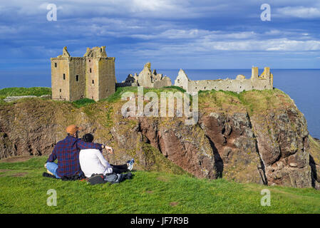 Touristen, die gerne am Dunnottar Castle, zerstörten mittelalterlichen Festung in der Nähe von Stonehaven auf Klippe entlang der Nordsee Küste, Aberdeenshire, Schottland, UK Stockfoto