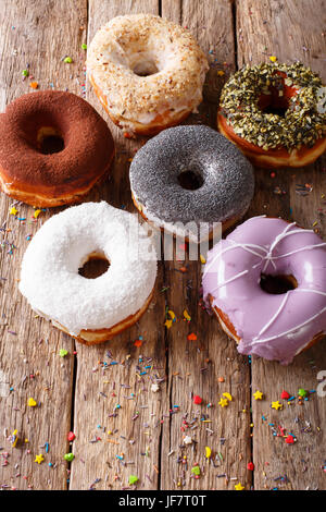 Leckere bunte Donuts mit Füllungen Nahaufnahme auf dem Tisch. Vertikal Stockfoto