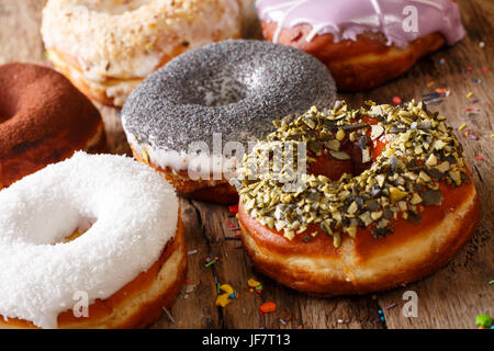 Hausgemachte glasierte bunte Donuts close-up auf dem Tisch. horizontale Stockfoto