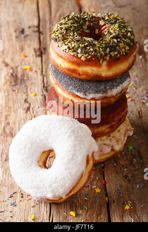 Stapel von verglasten bunte Donuts Nahaufnahme auf einem Tisch. vertikale Stockfoto