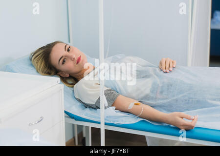 Nachdenkliche Frau transfundierten liegt im Krankenhaus Stockfoto
