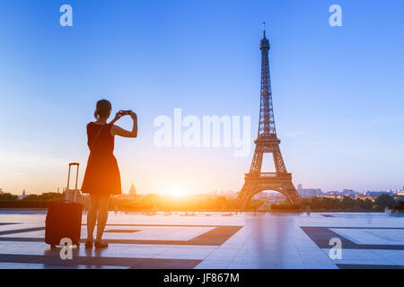 Frau Reisenden aufnehmen eines Fotos der Eiffelturm vom Trocadero mit ihrem Smartphone bei einem Wochenend-Trip nach Paris, Frankreich Stockfoto