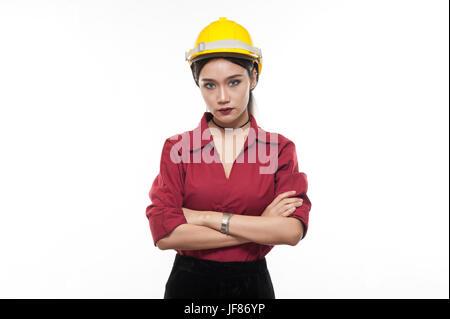 Asiatische Frau Ingenieur in rotem Hemd und gelbe Kappe Kreuzung Arme mit Ernst Emotion auf ihrem Gesicht. Menschen, die in Wirtschaft und Enginerring gestikulieren Stockfoto