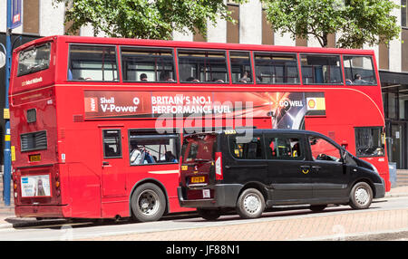 National Express Midlands Red Bus und ein schwarzes Taxi (Bewegungsunschärfe) im zentralen Birmingham, England, UK. Stockfoto