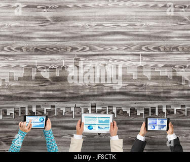 Gruppe von drei Personen mit Geräten in Händen arbeiten zusammen als Symbol der Vernetzung und Kommunikation Stockfoto