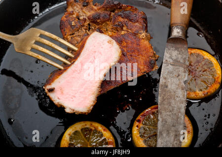 Schweinekotelett auf eisernen Pfanne angebraten Stockfoto