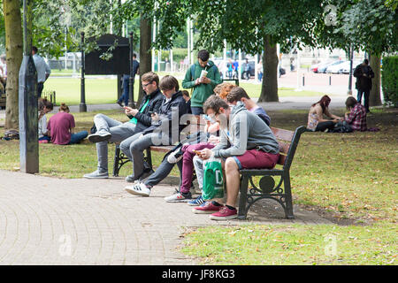 Pokemon Go - Spieler spielen in einem Park Stockfoto