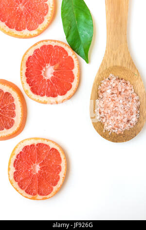 Ayurveda Gesicht Haut Peeling Inhaltsstoffe, rosa Himalayasalz in hölzernen Löffel, in Scheiben geschnitten, Grapefruit, grüne Blatt auf weißem Hintergrund, Schönheit, Gesundheit, wellness Stockfoto