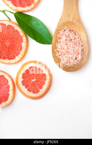 Ayurveda Gesicht Haut Peeling Inhaltsstoffe, rosa Himalayasalz in hölzernen Löffel, in Scheiben geschnitten, Grapefruit, grüne Blatt auf weißem Hintergrund, Schönheit, Gesundheit, wellness Stockfoto