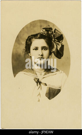 Ein fesselndes Porträt eines nicht identifizierten Mädchens, das einen Moment ruhiger Reflexion oder Neugier einfängt. Stockfoto