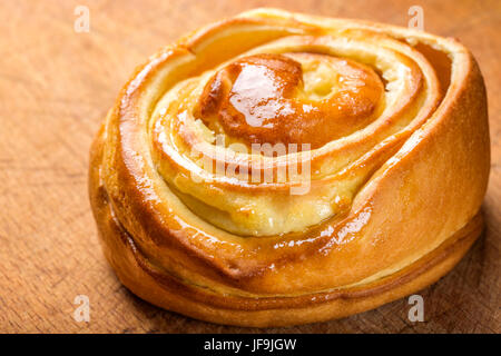 Nahaufnahme von frischen hausgemachten Zimt Brötchen. Svedish Küche. Dunklem Holz Stockfoto