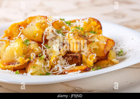 Bratkartoffeln mit Rührei und Parmesan-Käse auf weißen Teller Stockfoto