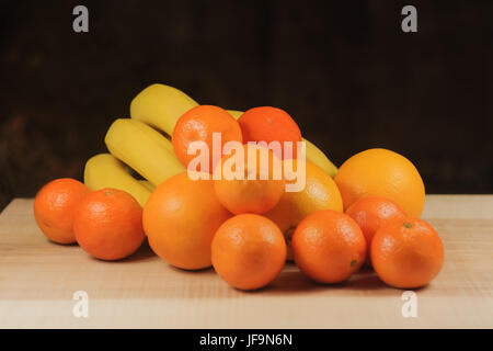 Orangen und Bananen liegen mit Mandarinen Stockfoto