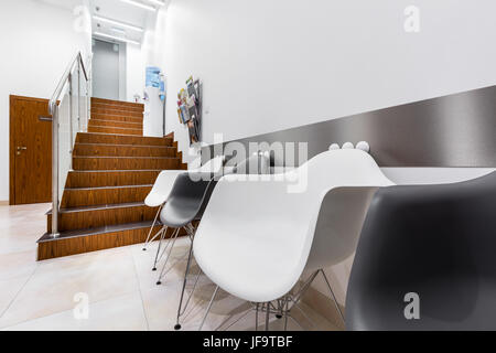 Klinik-Interieur mit weißen und schwarzen Stühlen im Wartezimmer Stockfoto