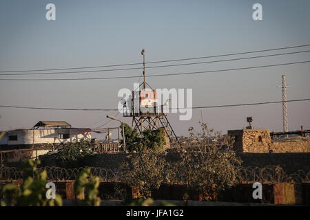 Rafah, Gaza. 29. Juni 2017. Ein ägyptischer Soldat auf einem Wachturm sieht wie Bulldozer zu arbeiten, auf die Schaffung einer Pufferzone entlang der ägyptischen Grenze zum Gazastreifen in Rafah, Donnerstag, 29. Juni 2017. Die Hamas geführten Innenministeriums sagte am Mittwoch die Schaffung eines 12 Kilometer langen (7,5-Meile) Ganges 100 Meter (330 Feet) breit war in den letzten persönlichen Verhandlungen mit ägyptischen Beamten vereinbart und ist Bestandteil der islamischen Terrorgruppe Anstrengungen zur Bekämpfung von Extremisten und Verbesserung der Beziehungen mit Kairo. Bildnachweis: Nidal Alwaheidi/Pacific Press/Alamy Live-Nachrichten Stockfoto