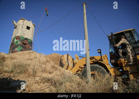 Rafah, Gaza. 29. Juni 2017. Eine palästinensische Maschinen arbeitet an Grenze zu Ägypten, in Rafah, Gaza-Streifen 29. Juni 2017. Palästinensische Sicherheitskräfte loyal zu Hamas Stand-by, wie Bulldozer einen Bereich für eine große Pufferzone an der Grenze zu Ägypten im südlichen Gaza Streifen Stadt von Rafah, am 29. Juni 2017 klar. Die Pufferzone soll auf einer Länge von 12 Kilometern und einer Breite von 100 m entlang der Grenze mit einer Straße und Sicherheitskameras laufen parallel, erweitern, laut Aussage ein Sicherheitsbeamter. Bildnachweis: Nidal Alwaheidi/Pacific Press/Alamy Live-Nachrichten Stockfoto