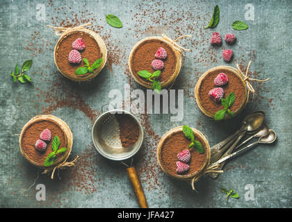 Hausgemachte Tiramisu in einzelnen Gläsern mit gefrorenen Himbeeren Stockfoto