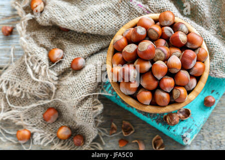 Haselnüsse in eine hölzerne Schüssel und alten Plünderungen. Stockfoto