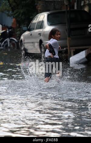 Manila, Philippinen. 30. Juni 2017. Ein Junge spielt auf einer überfluteten Straße nach Starkregen in Manila, Philippinen, 30. Juni 2017. Bildnachweis: ROUELLE UMALI/Xinhua/Alamy Live-Nachrichten Stockfoto