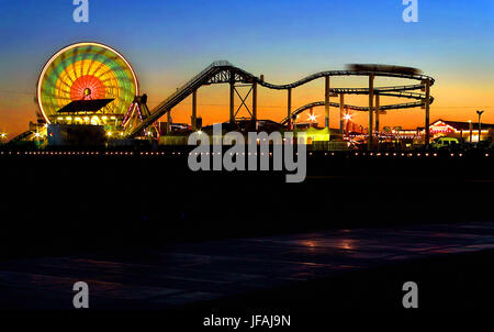 Santa Monica, Kalifornien, USA. 14. Juni 2002. Sonnenuntergang beleuchtet die Neonlichter und Fahrten über die Santa Monica Pier in Kalifornien über ein Jahrhundert alt jetzt mit Blue Streak Racer Holzachterbahn, original Karussell, die Peitsche, Karussells, Wurlitzer Orgeln und einem Funhouse. Bildnachweis: L.e. Baskow/ZUMA Draht/Alamy Live-Nachrichten Stockfoto